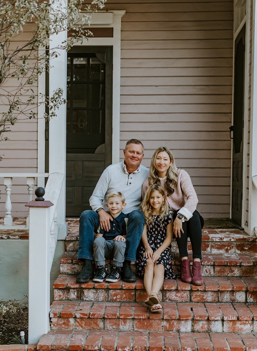 Jonathan St. Clair with his wife and two children on the steps of a historic home in Orange